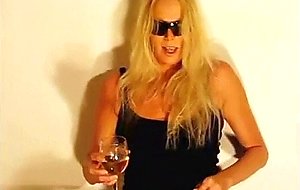 Blonde in jeans pees in wine glass