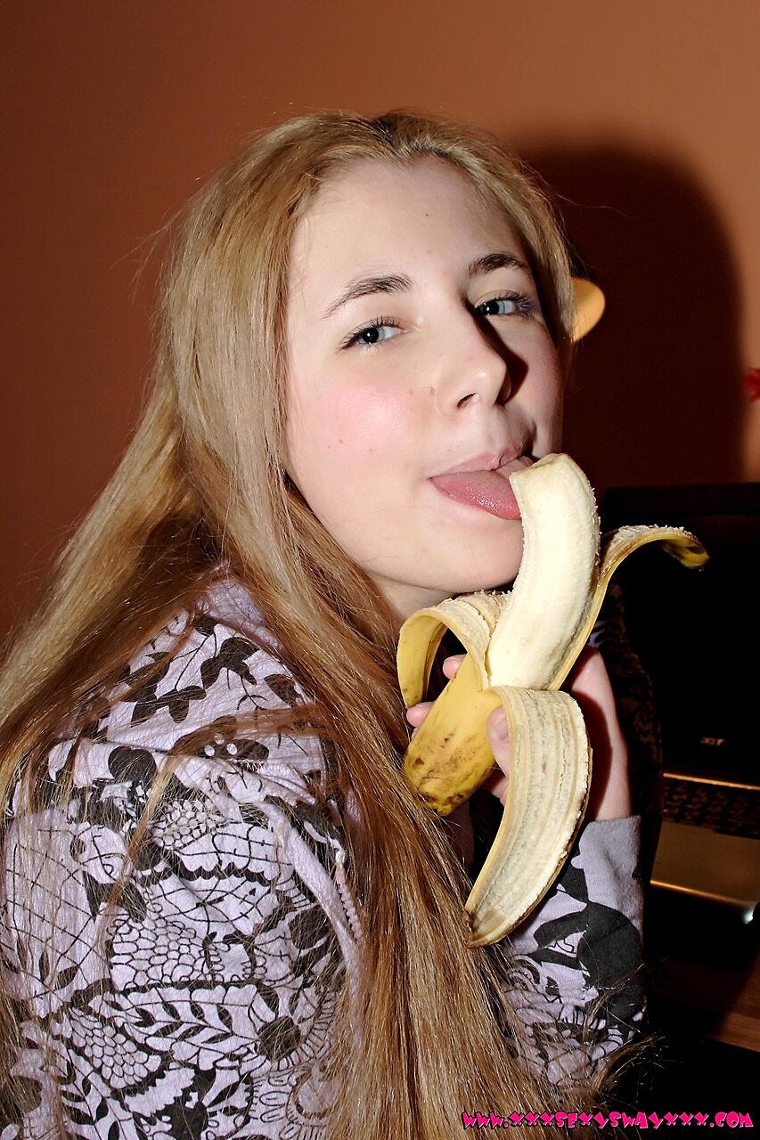 Young looking girl with long hair eats a banana before stripping to her socks