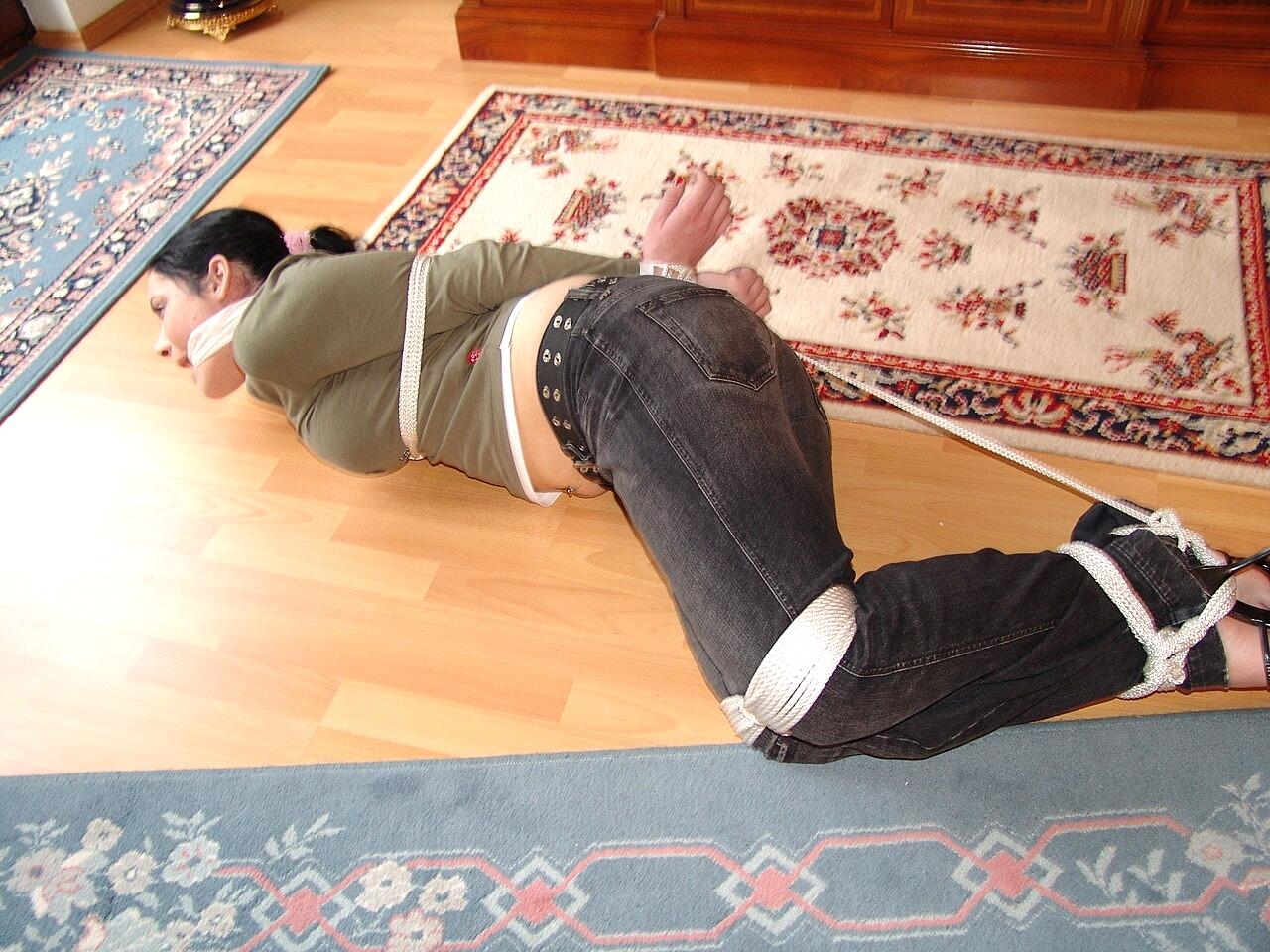 Dark haired girl is fitted with a cleave gag while rope bound in her clothes