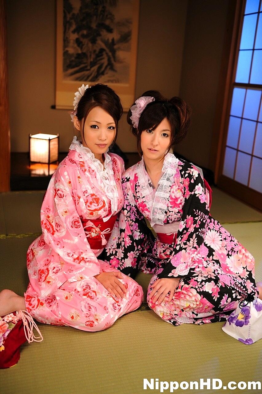 A pair of Japanese Geishas model together in their brightly colored kimonos